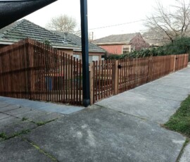Traditional treated pine timber fence vs Colorbond boundary wall with exposed wooden posts